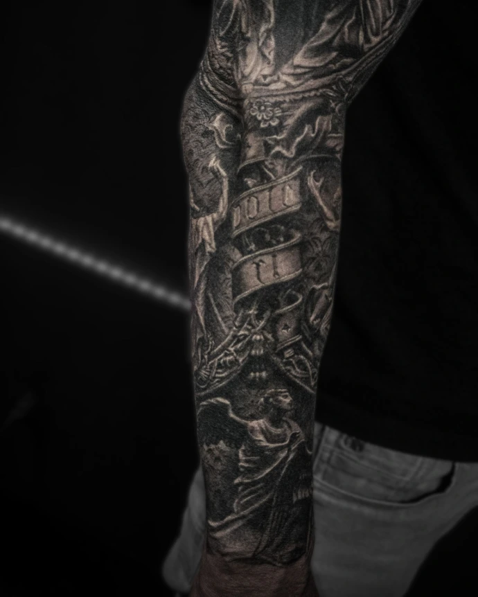 Inner arm detail showing a cherub angel and a banner with Latin script, shaded to look like carved masonry