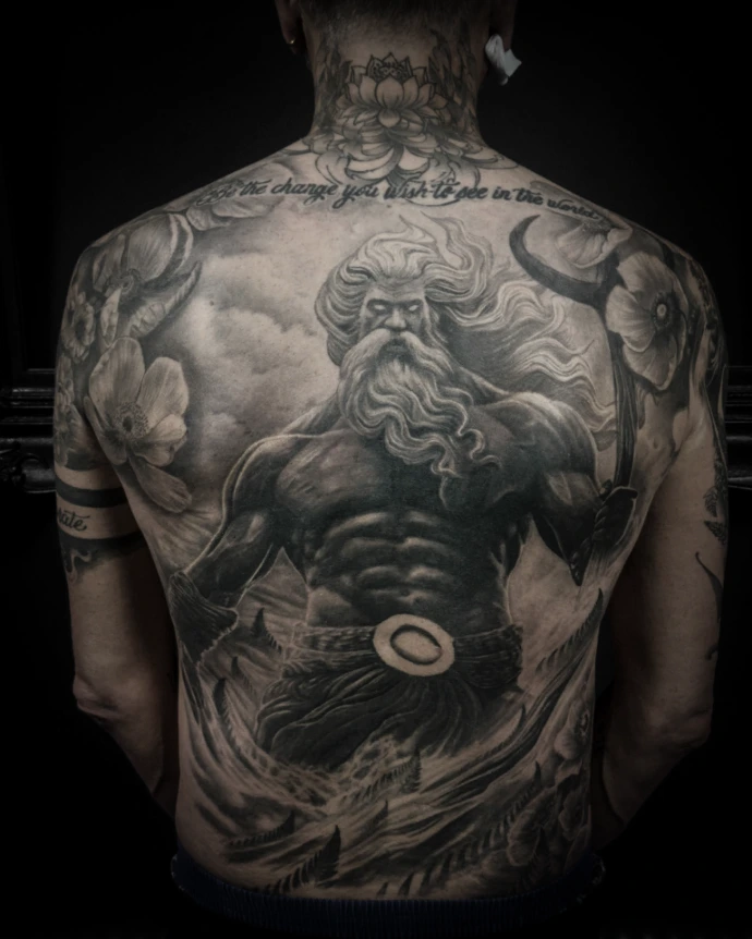 Large scale mythology tattoo on back featuring Poseidon/Neptune, stormy ocean waves, and floral elements