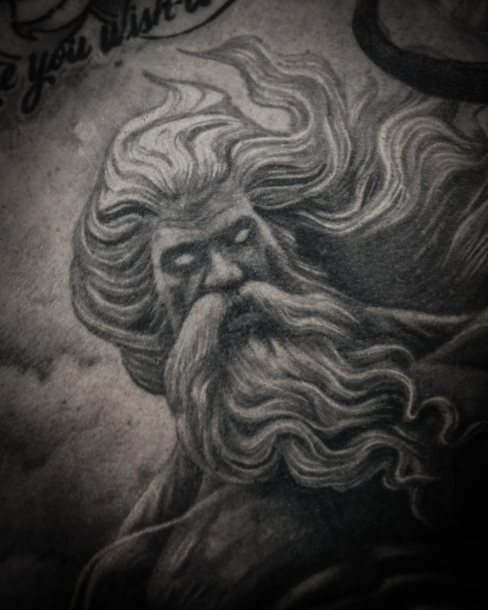 Closeup of Large scale mythology tattoo on back featuring Poseidon/Neptune, stormy ocean waves, and floral elements