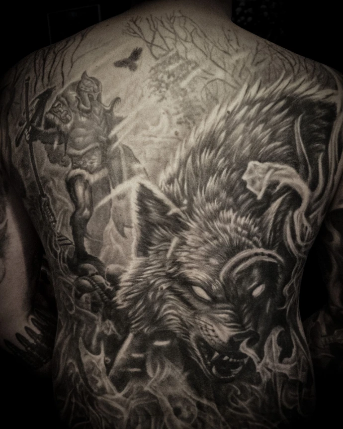 Large scale Norse mythology tattoo on the back featuring a battle scene between a Viking warrior and a giant wolf (Ragnarok).